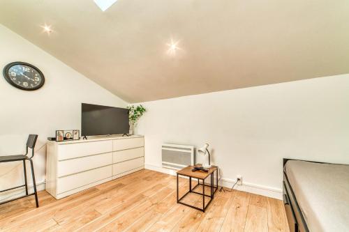 Una televisión o centro de entretenimiento en Le Nid Blanc - Agréable studio tout équipé