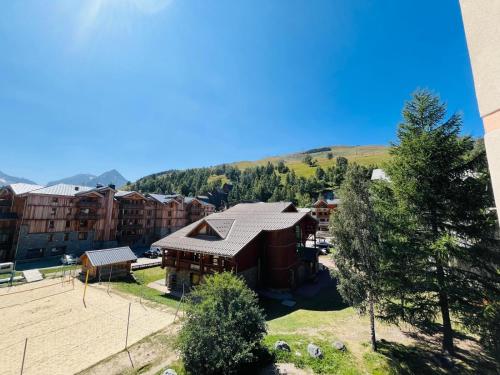 Vue de tête d'un bâtiment avec une montagne en arrière-plan dans l'établissement Le Sappey-Pied des pistes-Parking gratuit, à Les Deux Alpes