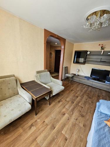 a living room with two couches and a tv at Apartment at Vitolu 30 in Liepāja
