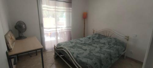 une chambre avec un lit, une table et une fenêtre dans l'établissement Maison Villa d'exception meublée piscine privée & cheminée a 2min plage et commerces, à Marseillan