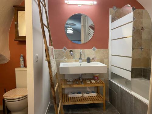 une salle de bain avec un lavabo et un miroir dans l'établissement Charmante maison de village, à Collias