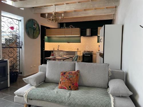 un salon avec un canapé et une cuisine dans l'établissement Charmante maison de village, à Collias