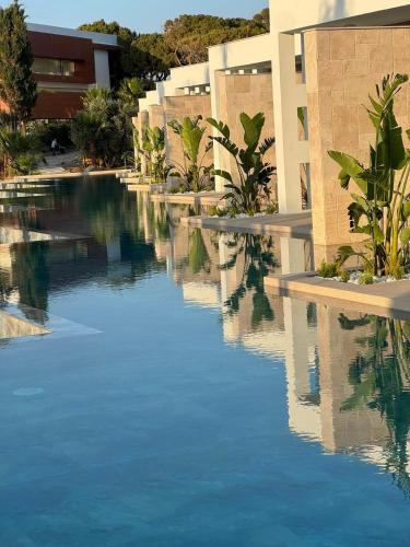 a pool of water in front of a building at Acapulco Resort Hotel in Kérynia
