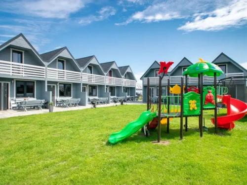 a playground with a slide in a yard at DOMKI u JAGODY II in Sarbinowo