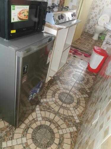 a kitchen with a refrigerator and a tv on top at Micasa Homes BnB D6 in Limuru