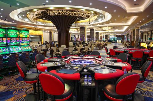 a casino with red chairs and poker tables at Acapulco Resort Hotel in Kérynia