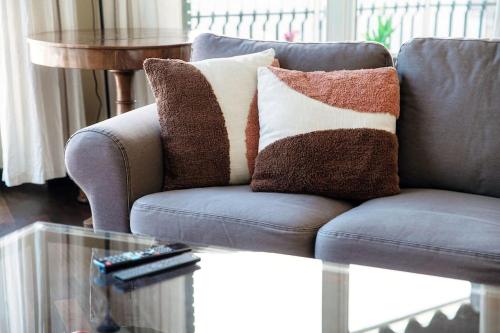 a couch with pillows on it in a living room at Elegante casa con Garage AC WiFi balcony in Como