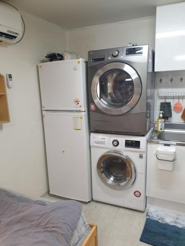 a kitchen with a refrigerator and a washer and dryer at Cheongryangri Zebra Cinema & Rooftop in Seoul