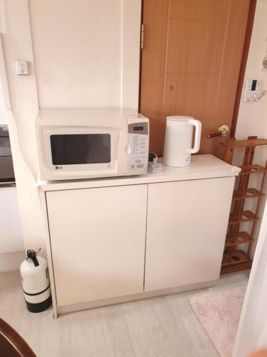 a microwave sitting on top of a white refrigerator at Cheongryangri Zebra Cinema & Rooftop in Seoul