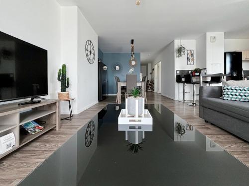 un salon avec une télévision, un canapé et une table dans l'établissement Lovely Apartment Disneyland Paris - Rentaway BnB, à Montévrain