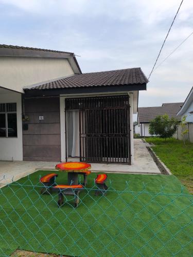 a backyard with a table and chairs on the grass at AZ Homestay 1 Gambang in Kuantan