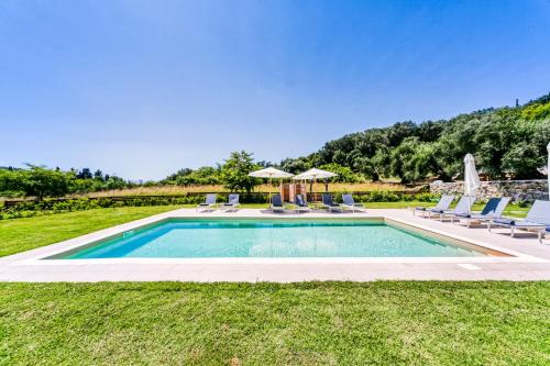 a pool with chairs and umbrellas in a yard at Kumquart estate- Grape fruit in Aspiotádes