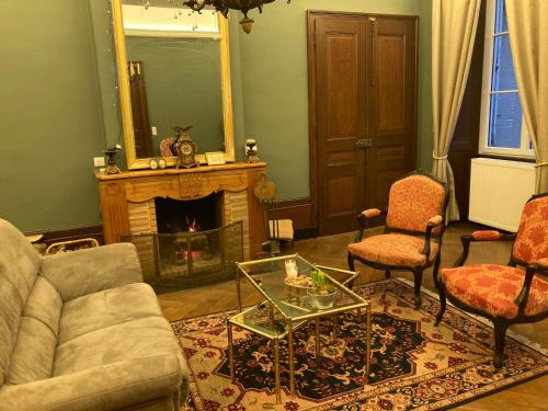 a living room with a couch and a fireplace at La demeure d'Aiglepierre in Aiglepierre