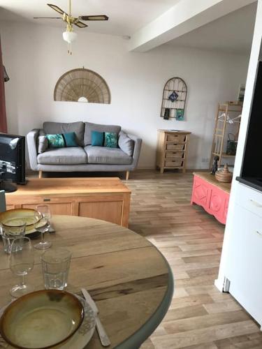 un salon avec une table et un canapé dans l'établissement Studio TY ZEN À 50m de la mer , des plages et du GR34, à Saint-Quay-Portrieux