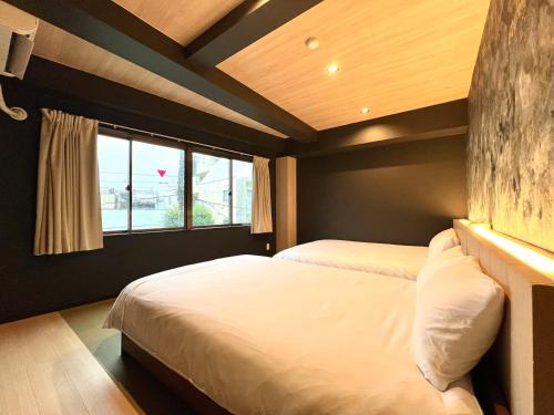 une chambre avec deux lits et une fenêtre dans l'établissement Asakusa-Smile, à Tokyo