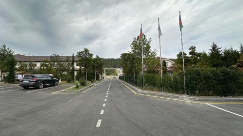 a car parked in a parking lot with two flags at Hill Park Gusar in Qusar