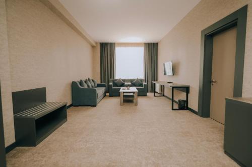 a living room with couches and a table at Hill Park Gusar in Qusar