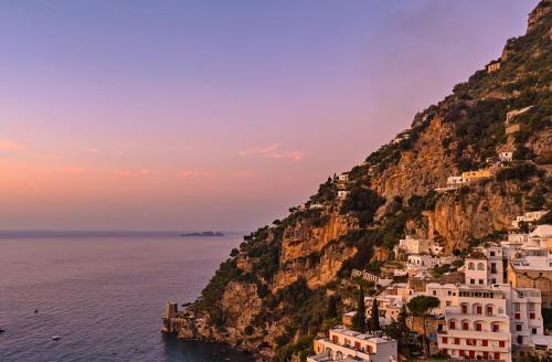 a view of the amalfi coast at sunset at Hotel Punta Regina in Positano
