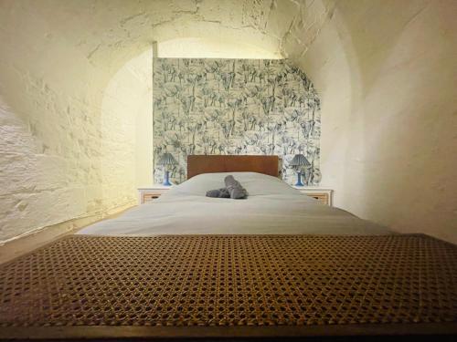 - une chambre avec un lit blanc et un mur à motifs dans l'établissement Chez Flora ! 344, à Rouen