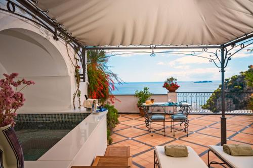 a patio with a table and a view of the ocean at Hotel Punta Regina in Positano