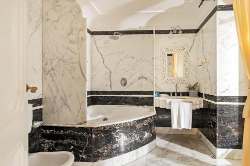 a bathroom with a tub and a sink at Hotel Punta Regina in Positano