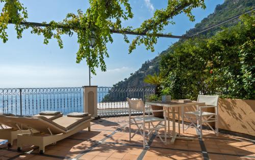 a patio with a table and chairs and a view of the ocean at Hotel Punta Regina in Positano