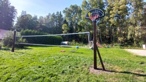 a basketball hoop in a yard with at Apartamenti ar verandu diviem cilvēkiem in Plieņciems