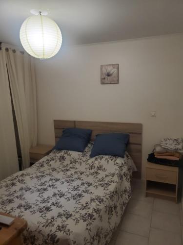 - une chambre avec un lit avec des oreillers bleus et un éclairage dans l'établissement Vieux port appartement, à Marseille