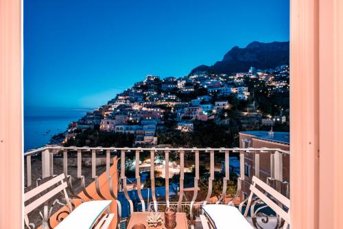 a view of a city from a balcony with chairs at Hotel Punta Regina in Positano