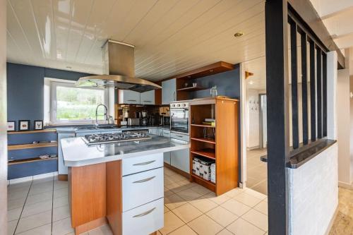 une cuisine avec un évier et une cuisinière dans l'établissement Maison tout confort 10 personnes - La Halte Bigoudene, à Gourinet