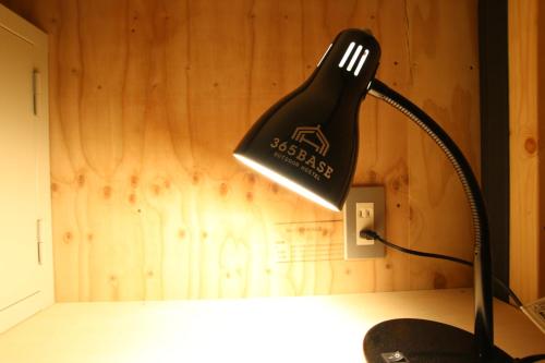 a black lamp sitting on top of a desk at 365BASE outdoor hostel in Hamamatsu