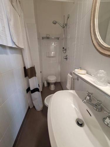 a white bathroom with a toilet and a sink at Hotel Villa Tiziana in Marina di Pietrasanta