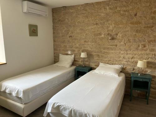 Sennecey-le-GrandにあるAuberg'Innのベッド2台、ランプ2つ(テーブル付)が備わる客室です。