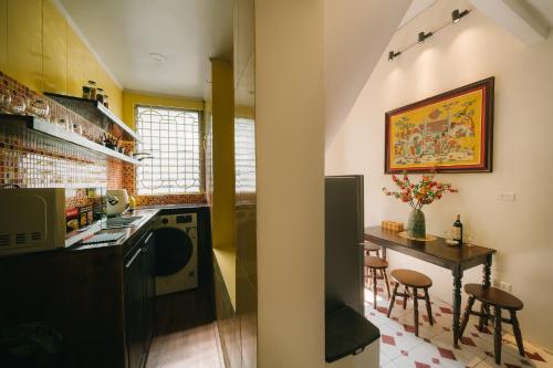 a kitchen with a table and a small table with chairs at High-class French villa 168m2 by SSens Homes in Hanoi