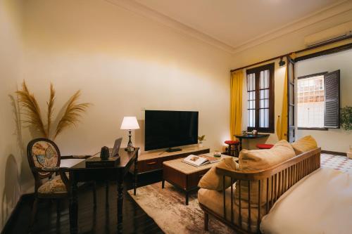 a living room with a couch and a television at High-class French villa 168m2 by SSens Homes in Hanoi