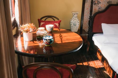 a table with vases and cups on top of a bed at High-class French villa 168m2 by SSens Homes in Hanoi