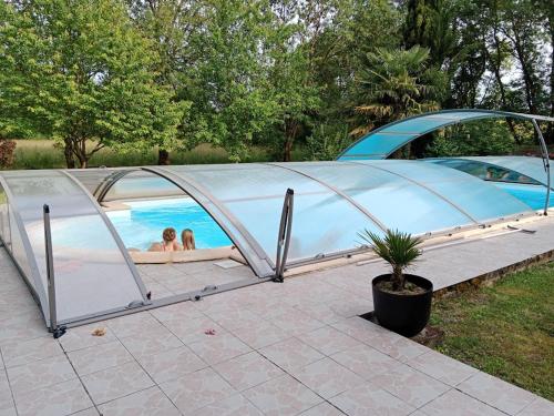 - 2 personnes dans une tente en forme de dôme au bord de la piscine dans l'établissement Domaine de Pladuc, à Lachaise