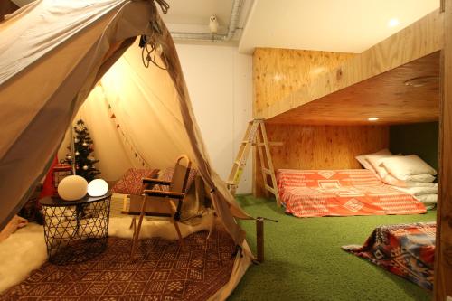 a bedroom with a bunk bed and a ladder at 365BASE outdoor hostel in Hamamatsu