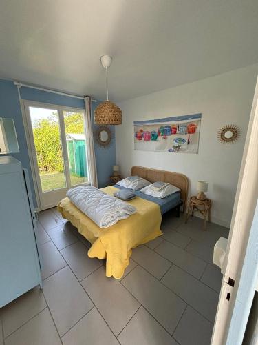 une chambre avec deux lits et une fenêtre dans l'établissement C'est une maison bleue, juste à côté de la plage..., à Barneville-Carteret