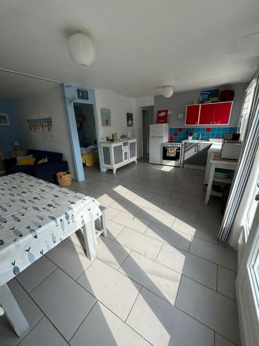 un salon avec une cuisine et une table dans l'établissement C'est une maison bleue, juste à côté de la plage..., à Barneville-Carteret
