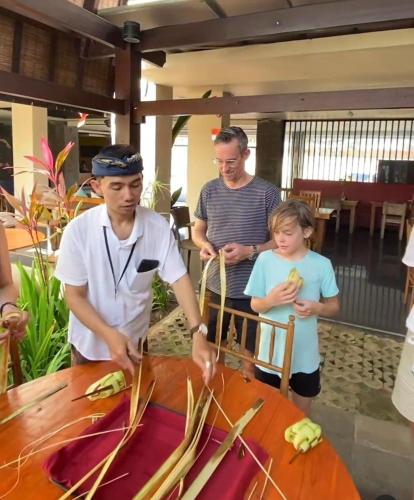 a group of people standing around a table with food at Abian Harmony Hotel in Sanur