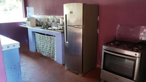 eine Küche mit einem Kühlschrank aus Edelstahl und einem Herd in der Unterkunft Sr & Sra White in Praia Da Caueira