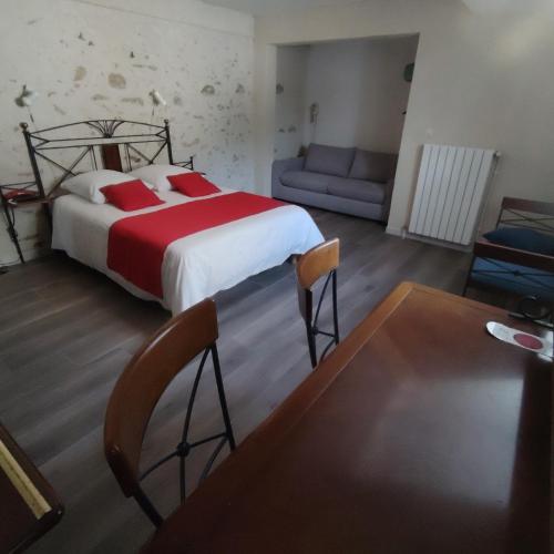 a bedroom with a large bed and a couch at A La Porte Saint Jean in La Souterraine
