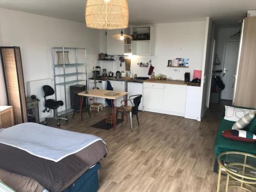 une chambre avec un lit et une cuisine avec une table dans l'établissement Grand studio proche de Paris, à Noisy-le-Sec