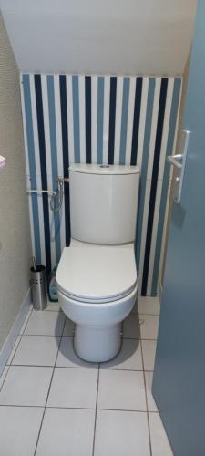 des toilettes blanches dans une salle de bain à rayures bleues et blanches dans l'établissement Maisonnette T2 avec piscine chauffée et plage à 300m, à Le Fort-Bloqué