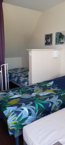 - une chambre d'hôtel avec 2 lits et une couverture colorée dans l'établissement Maisonnette T2 avec piscine chauffée et plage à 300m, à Le Fort-Bloqué