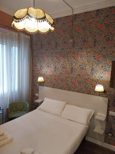 a bedroom with a bed and a floral wall at Hotel Montreal in Florence