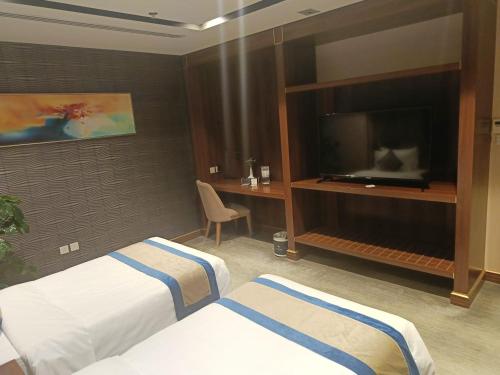 Una televisión o centro de entretenimiento en Al Malqa Elite Hotel