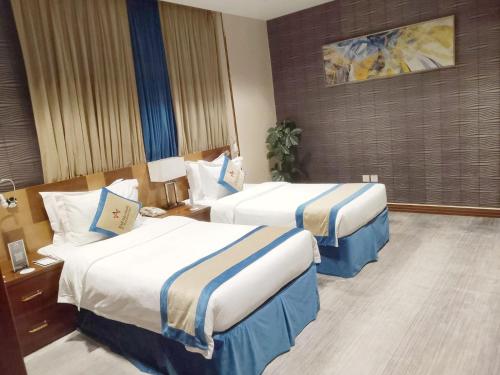 Una cama o camas en una habitación de Al Malqa Elite Hotel