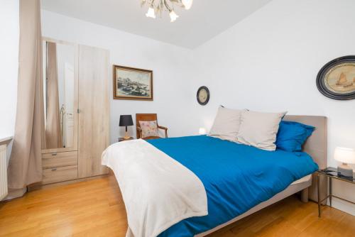 a bedroom with a blue and white bed in it at Splendide maison de maître à 50m du port et 100m de la plage in Barfleur